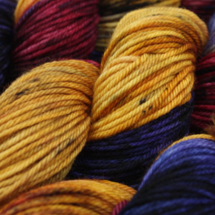 Close-up of colorful yarn skeins in yellow, purple, and red.